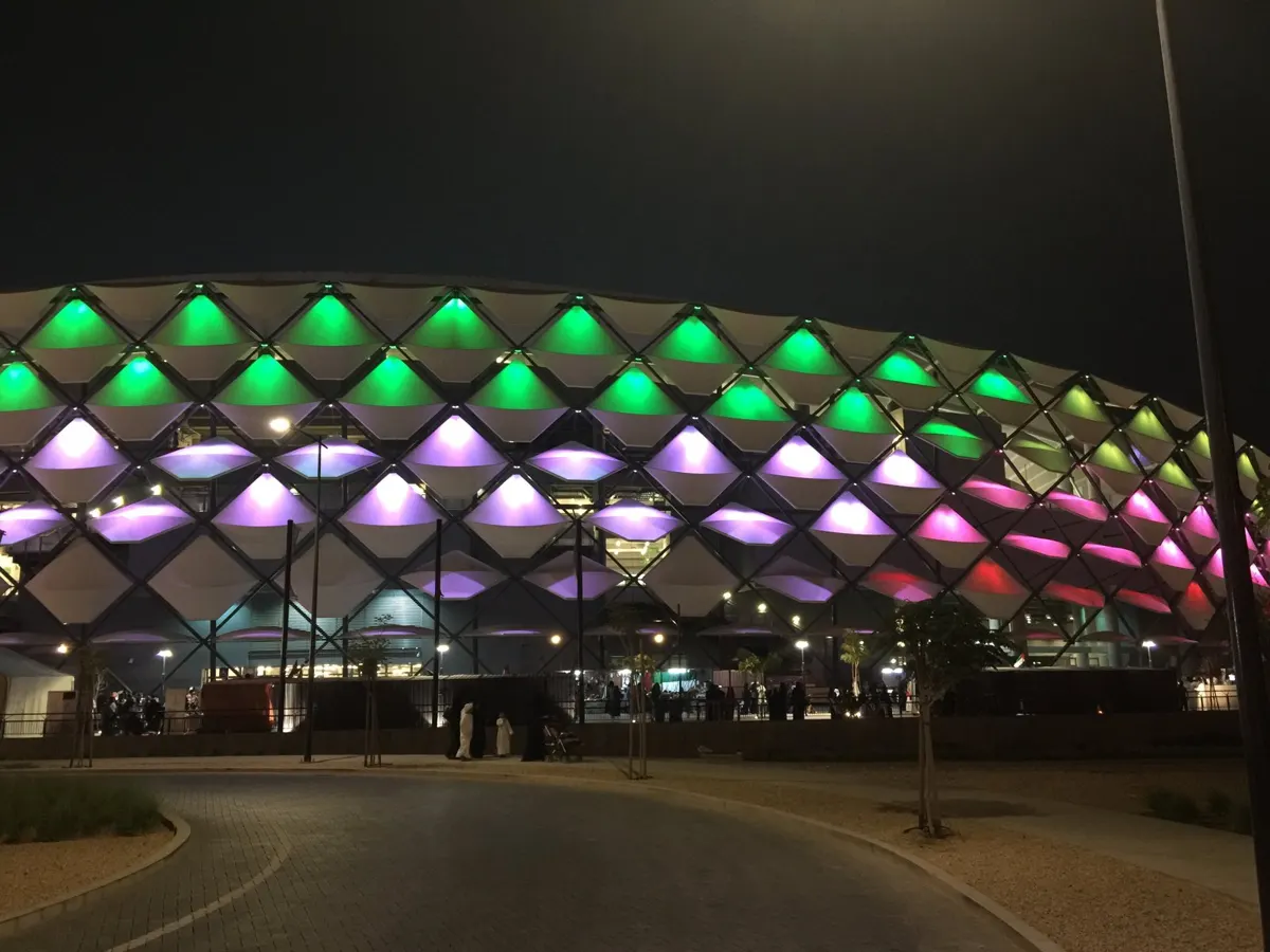 Hazza bin Zayed Stadium in Al Ain lit up in green, white and red at night