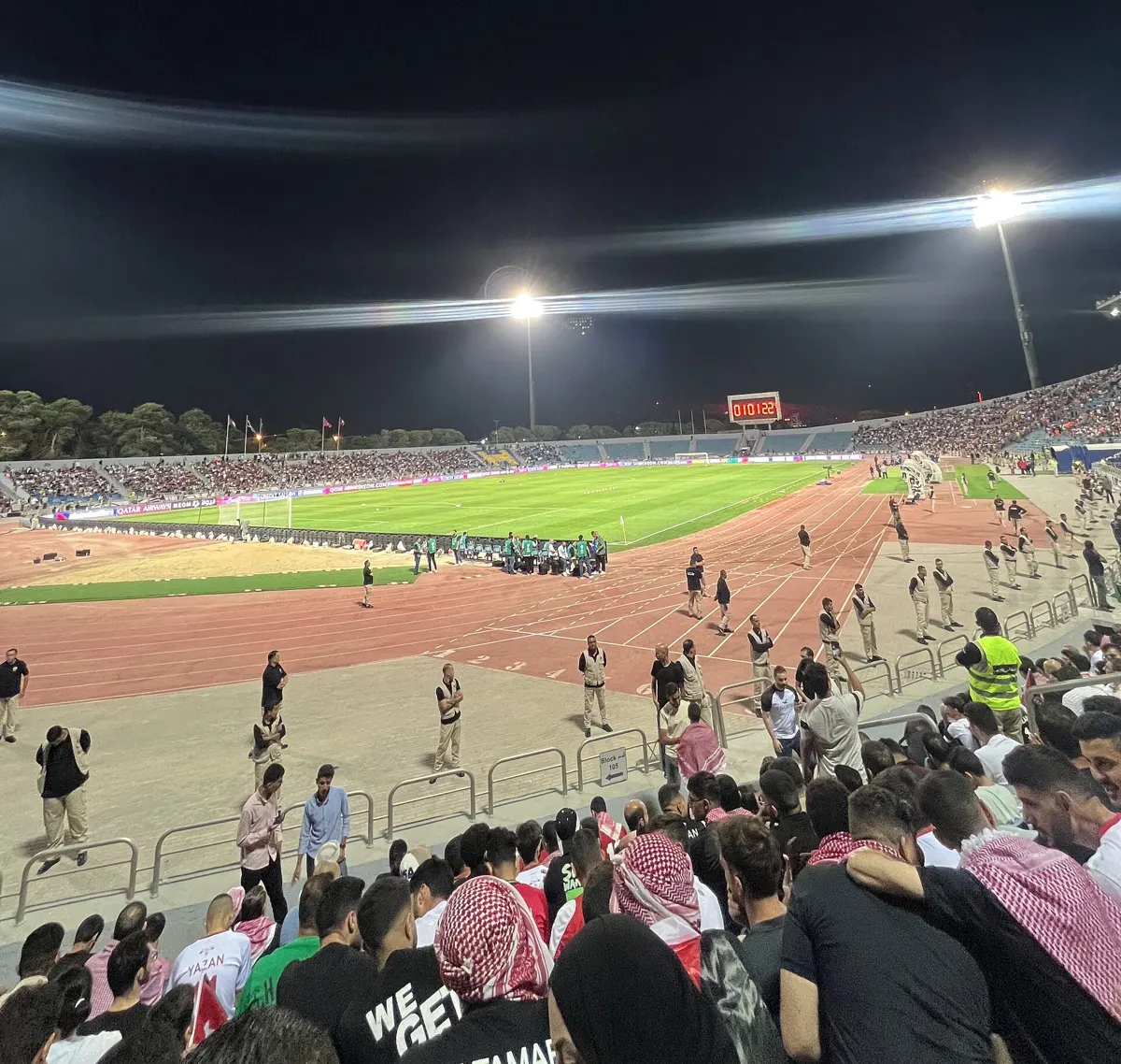 Floodlit pitch and packed stands at the Amman International Stadium in Jordan during a night match
