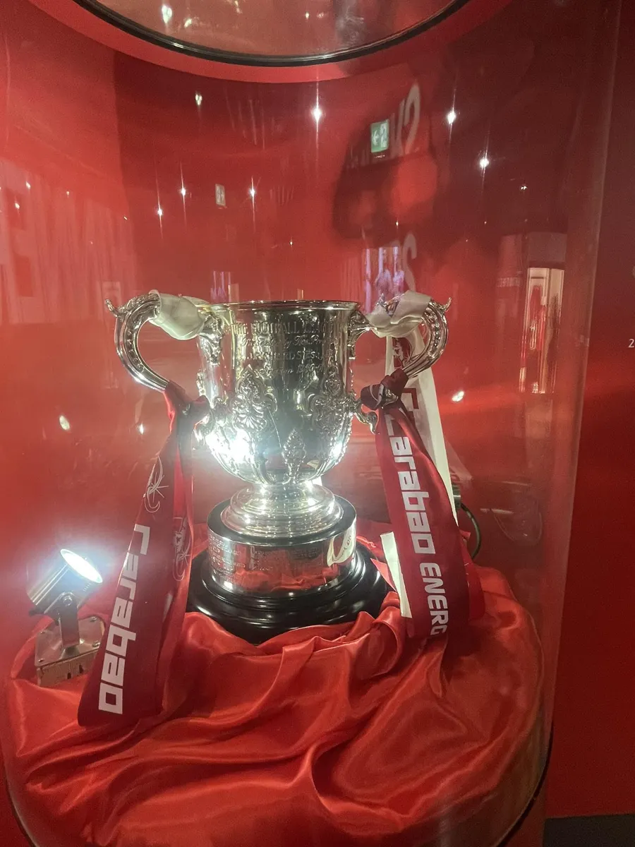 The silver EFL Cup trophy with Carabao ribbons on display in a glass case at the Liverpool FC museum