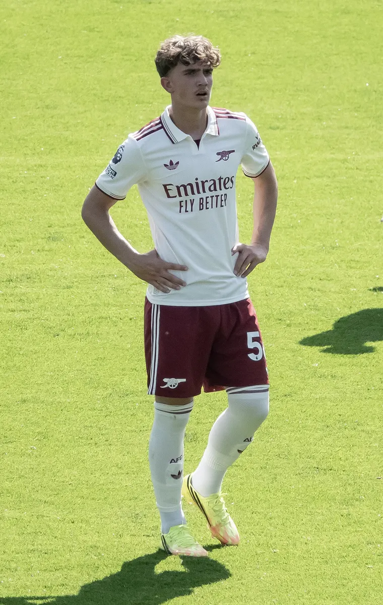 Arsenal teenager Max Dowman in a white and maroon away kit, standing on the pitch with his hands on his hips during a Premier League game at Crystal Palace in May 2026